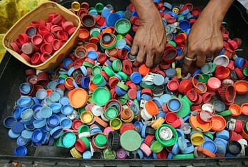 person hands on assorted color plastic lid lot